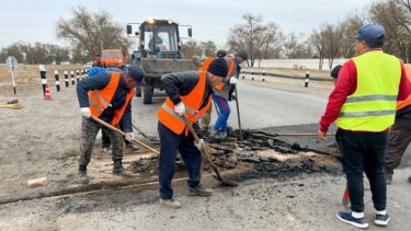 Үштөбеде жол жөндеушілер темір жол рельсінің үстінен асфальт төсеп тастаған